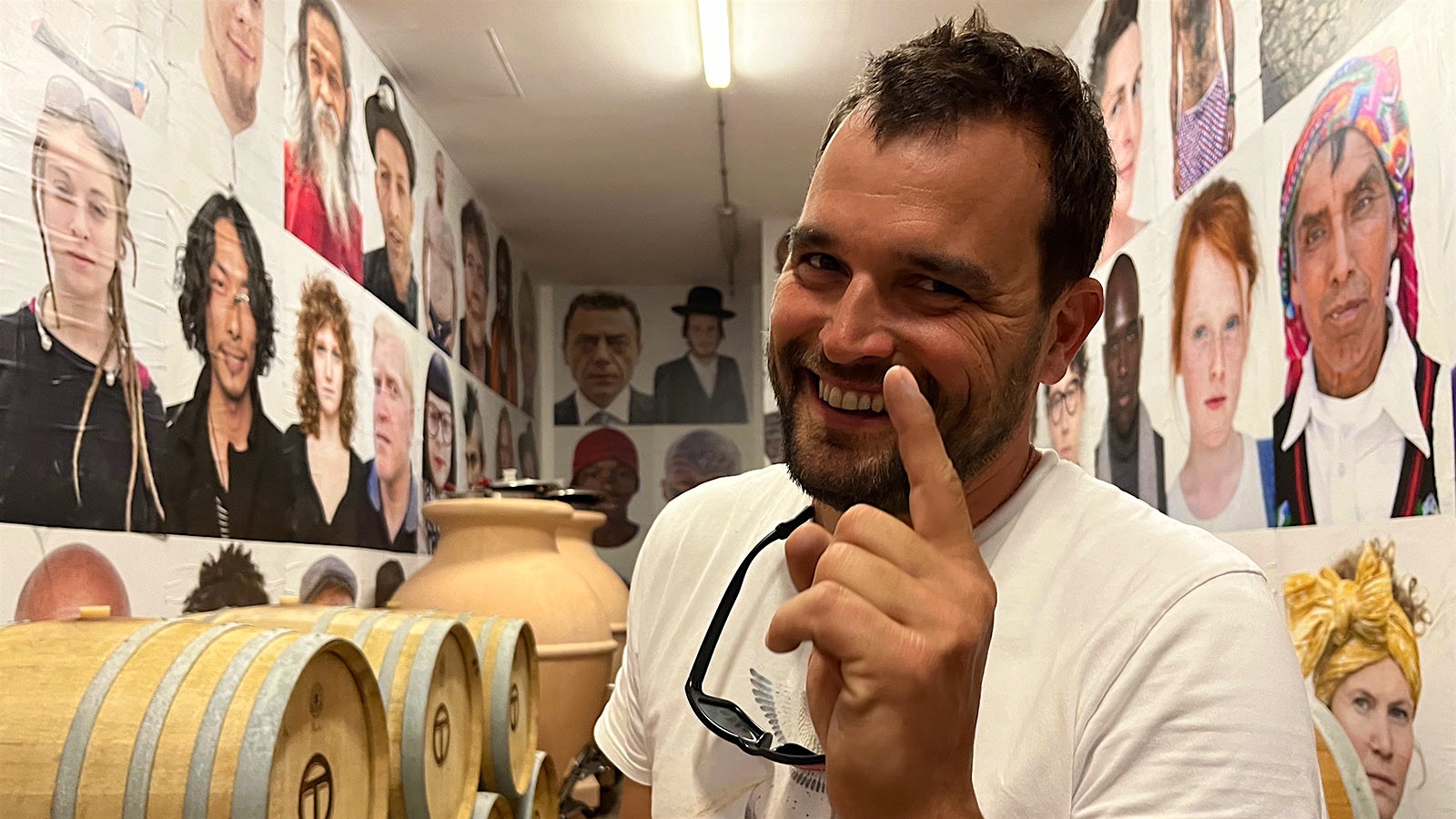 Rocco Toscani in Toscani's cellar, with a selection of his photographs on the walls